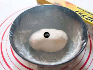 3、没有烤箱照样做出香浓芝士风味薄底披萨,揉好的面团放在碗里，覆上保鲜膜，室温25摄氏度下，发酵30分钟左右。如果室温偏低，发酵时间需要适当延长。面团发酵到按下慢慢回弹，不会出现裂纹为宜。