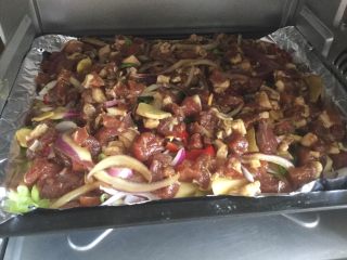 13、孜然羊腿肉,将烤盘放入150度预热10分钟的烤箱内开适烘烤，时间为四十分钟。如果喜欢烤干一点的，可以适当延长10分钟左右。烤半一时再撒一遍孜然面。