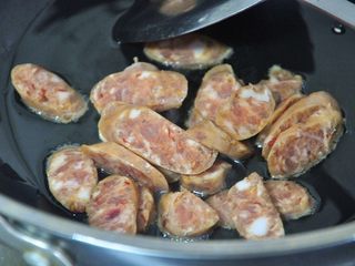 3、香肠焖饭, 锅中倒入少许油，放入香肠片，