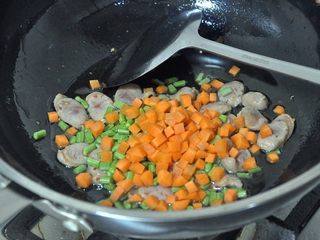 5、香肠焖饭,倒入胡萝卜、豇豆，翻炒2分钟。