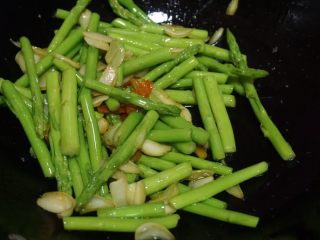 5、蚝油百合汇芦笋,然后下入芦笋，撒适量盐调味，翻炒均匀即可装盘