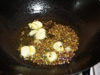 4、尖椒兔,锅内留少许底油，放入花椒粒，大蒜，姜末爆香锅