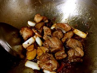 6、排骨豆角焖面,加入少许料酒和少许生抽继续翻炒，炒至排骨上色。