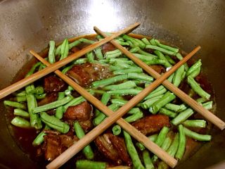 11、排骨豆角焖面,这时排骨炖烂，将豆角放入排骨中，然后往排骨豆角上横放几根筷子，利于架起面条。