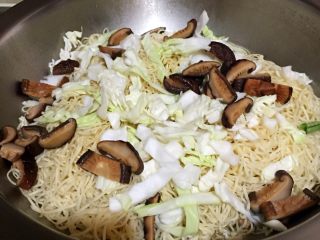 12、排骨豆角焖面,然后将面条均匀铺放于排骨豆角上，再将圆白菜丝、香菇铺放于面条上。如果排骨汤少的话，就再加些开水，切记不可太多汤。