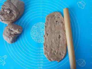 11、黑麦核桃红糖吐司,把面团拿出排气，分割四块，擀出长条，卷回来