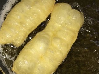 4、简单方便家庭自制小油条,等锅里的油温达到7.8成熟，可以先放一块面团下去，马上浮起来就可以下油条了。