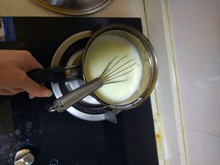 6、家庭式冰淇淋,把牛奶蛋黄液放到电磁炉上面再加热一下，边加热边快速搅拌(一定要快速搅拌，不然会成蛋花液)，加热到感觉要沸的时候就可以离火了，差不多80摄氏度左右，(再备注一下，有的用那种可以生吃的鸡蛋，比如土鸡蛋，那么就可以不用杀菌了)