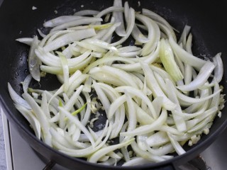 8、孜然杏鲍菇,接着放入洋葱翻炒均匀