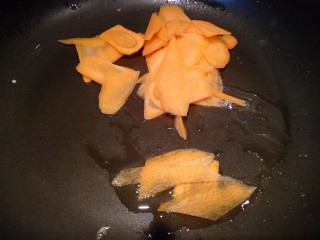 10、三色拌黄瓜, 锅里倒少许油，放入胡萝卜片。