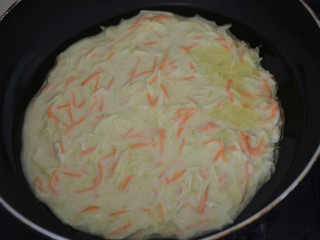 5、茭瓜鸡蛋饼,尽快用勺子将未成型的面糊摊圆。