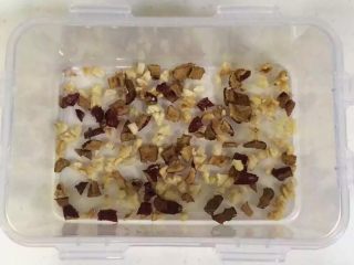 4、红枣核桃糯米糕,把切好的红枣碎和核桃碎放入保鲜盒内。