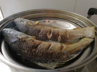 10、年夜菜_麻辣清蒸江鲫鱼&一锅两吃,蒸好的鱼，掏出鱼肚子里的葱姜和花椒粒，倒掉盘子里的汤水。