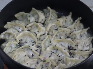 11、脆底煎饺（速冻饺子的救星）,面粉水蒸发的差不多时候，可撒些黑芝麻和葱花，增色增味（没有可省略），转小火加热，至水分完全蒸发，底部出现薄薄一层金黄色锅巴时，翻面