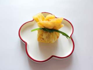 11、芦笋虾仁钱袋蛋包饭（适合15个月以上的宝宝）,把摊好的蛋饼里放入炒好的饭团，包起来，用芦笋系上即可