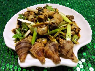 8、香葱拌小海螺,拌好爽口的小海螺装入盘中用海螺壳做装饰