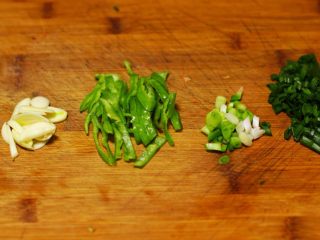 1、快手炒面,大蒜切片 ,青椒切丝 ,香葱切碎,葱白葱绿分开放