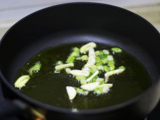 5、快手炒面,锅里倒油,油热后,下葱白和大蒜爆香