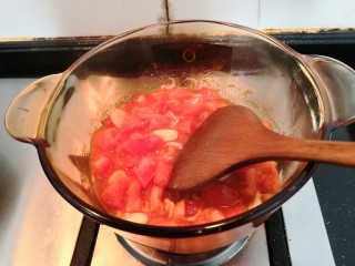 11、冬日暖心菜—西红柿虾皮热汤面,用铲子，把西红柿，翻炒至出汁