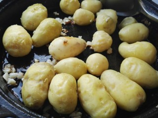 5、麻辣孜然小土豆,放入小土豆煎制(煎之前用刀把小土豆压扁，我忘提前压扁了，倒锅里后用松肉锤压的，一压扁占地方，有点太满了)。