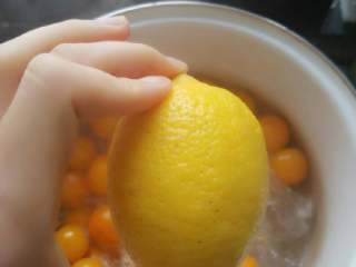 4、蜜渍金桔酱,取一个新鲜的柠檬，榨汁倒入锅中，小火煮半小时