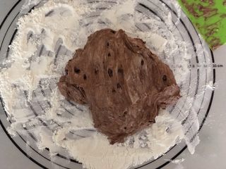 7、米歇尔可可面包,发酵好后,硅胶垫上撒一层干粉,把面团用刮板移到垫子上。