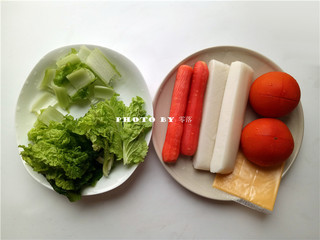 1、番茄年糕汤,备好食材：年糕、胡萝卜、番茄、小青菜、芝士片；番茄洗净，顶部划十字刀；小青菜洗净，菜茎，菜叶分开；