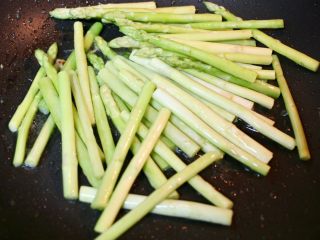 8、洋葱炒蛋配黑椒白芦笋,加油进锅，调大火至油出白烟，加入白芦笋