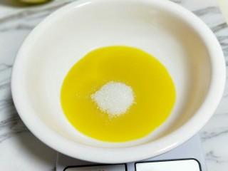 1、春节家宴饭后甜点#橙汁戚风蛋糕#,首先将橙汁和白砂糖放在器具中，手动打蛋器打至糖融化。