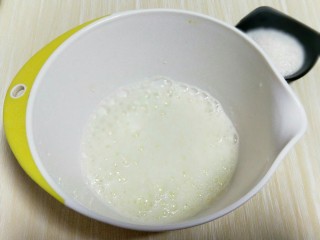 7、春节家宴饭后甜点#橙汁戚风蛋糕#,电动打蛋器将蛋白高速打发至呈现鱼眼泡时，加入三分之糖，继续高速打发，蛋清泡消失，细腻时再加入三分之一的糖，继续打发。