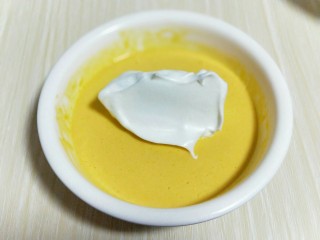 11、春节家宴饭后甜点#橙汁戚风蛋糕#,取三分之一的蛋白霜加入蛋黄糊中，翻拌直至看不到蛋白霜。