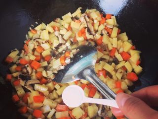 7、三丁面,接着放盐 根据菜量 放入适量的盐 我家里三个大人一个孩子吃饭 菜量是一根红萝卜 一个土豆 七八个香菇 然后我放了两勺盐 这个菜汤要稍微咸一点