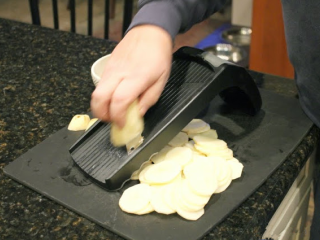 1、冬日温暖烩菜—芝士烩土豆片,烤箱预热至162度。土豆去皮洗净，用工具刨成约3毫米的薄片。