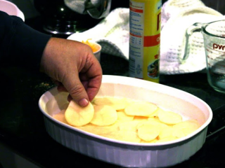 4、冬日温暖烩菜—芝士烩土豆片,将一半的土豆片整齐码放入烤碗中，把半锅奶酪酱倒在土豆的上。再码放剩下土豆片，然后倒入剩下的奶酪酱即可。