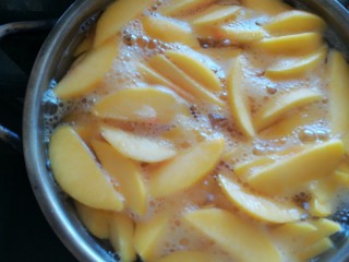 6、糖水黄桃,盖上盖子，大火烧开，用勺子小心翻动一下，让盐和冰糖均匀分布。