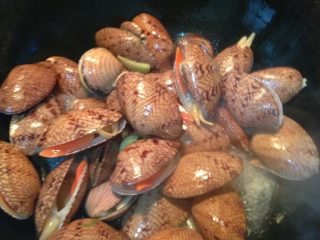 5、酱爆芒果贝,加入料酒翻炒一分钟；