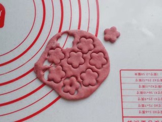 14、红糖椰蓉三角包,揉均匀的红面团先擀成薄面皮，然后用花朵小模具扣出几朵小花；