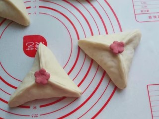 15、红糖椰蓉三角包,将扣出的小花朵沾点水，沾在三角包中间；