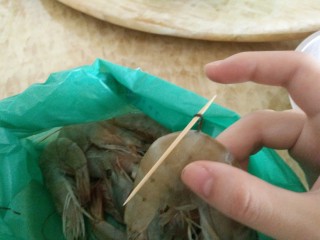 1、客人来了怎么办!中午吃什么!,虾线大家应该都会处理吧?用牙签从中间穿过去,挑出,拉出来。虾线就非常完整地取出来了。