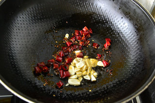 7、家庭版宫保鸡丁,加入姜蒜片继续煸炒片刻