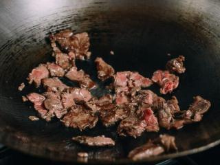 3、油条牛柳,锅烧热，看到冒烟在锅周围撒上一大勺油。加入牛肉翻炒2至3分钟直到变成褐色。从锅中取出，放在一边。