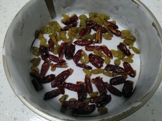 16、家庭版甑糕,模具铺上油纸，先铺一层枣和葡萄干。