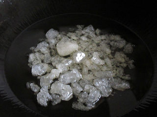 6、神仙肉,将炒锅烧稍微热，倒入适量的食用油，加入冰糖。小火煸炒，记住一定要小火