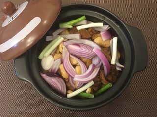 11、红烧牛肉(大白豆+小芒果版),好了之后,倒入砂锅或者平常炒菜的锅,把洋葱和葱放进去,小火炖十分钟