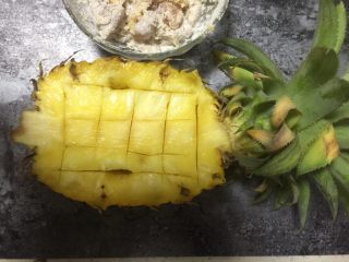 5、糖醋菜＋菠萝咕噜肉,把菠萝切半后，用刀把四周划出长方形的形状，中间的菠萝肉切成2cm左右方块后，用勺子把它挖出来备用。(注意头的部分留住不要切，这样出来的菠萝碗会更好看)