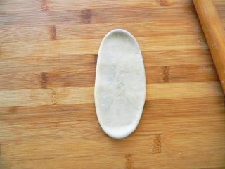 4、暖心壶紫薯酥,包好的面团先擀成长椭圆形