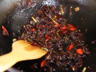 6、麻辣鱿鱼香锅,锅中放入豆瓣酱和豆豉，煸炒出红油，这里可以加一汤匙料酒，使酱料呈润泽冒泡状。