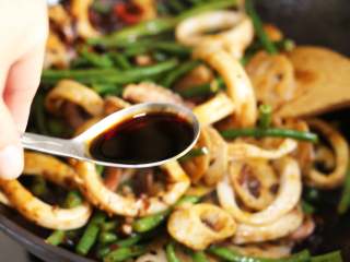 8、麻辣鱿鱼香锅,调味淋入生抽，加入糖，酌情加少许盐，然后加入小半碗水翻匀。