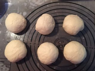 4、热狗面包,取出压扁排气，分割成等分量的6个，滚圆，松弛15分钟