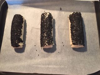 8、热狗面包,表面沾上芝麻后放入烤盘里，最好是白芝麻，我家缺货